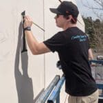 Brandyn Person painting letters on a wall.