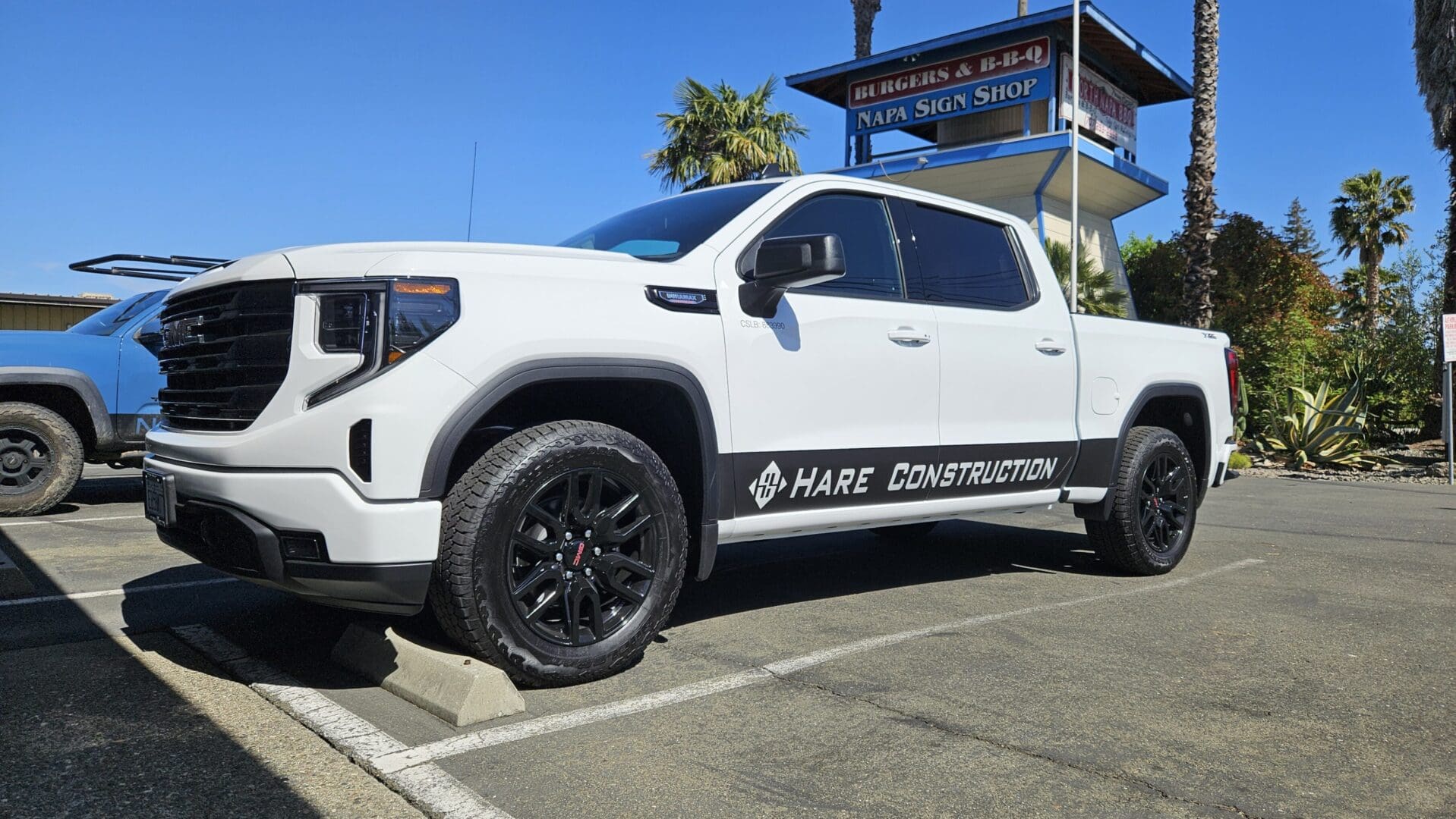 White pickup truck parked in sunny lot.