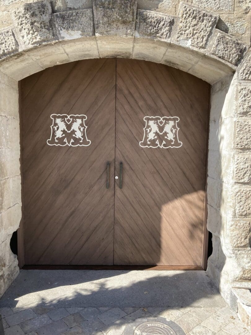 Wooden arched door with decorative emblems.