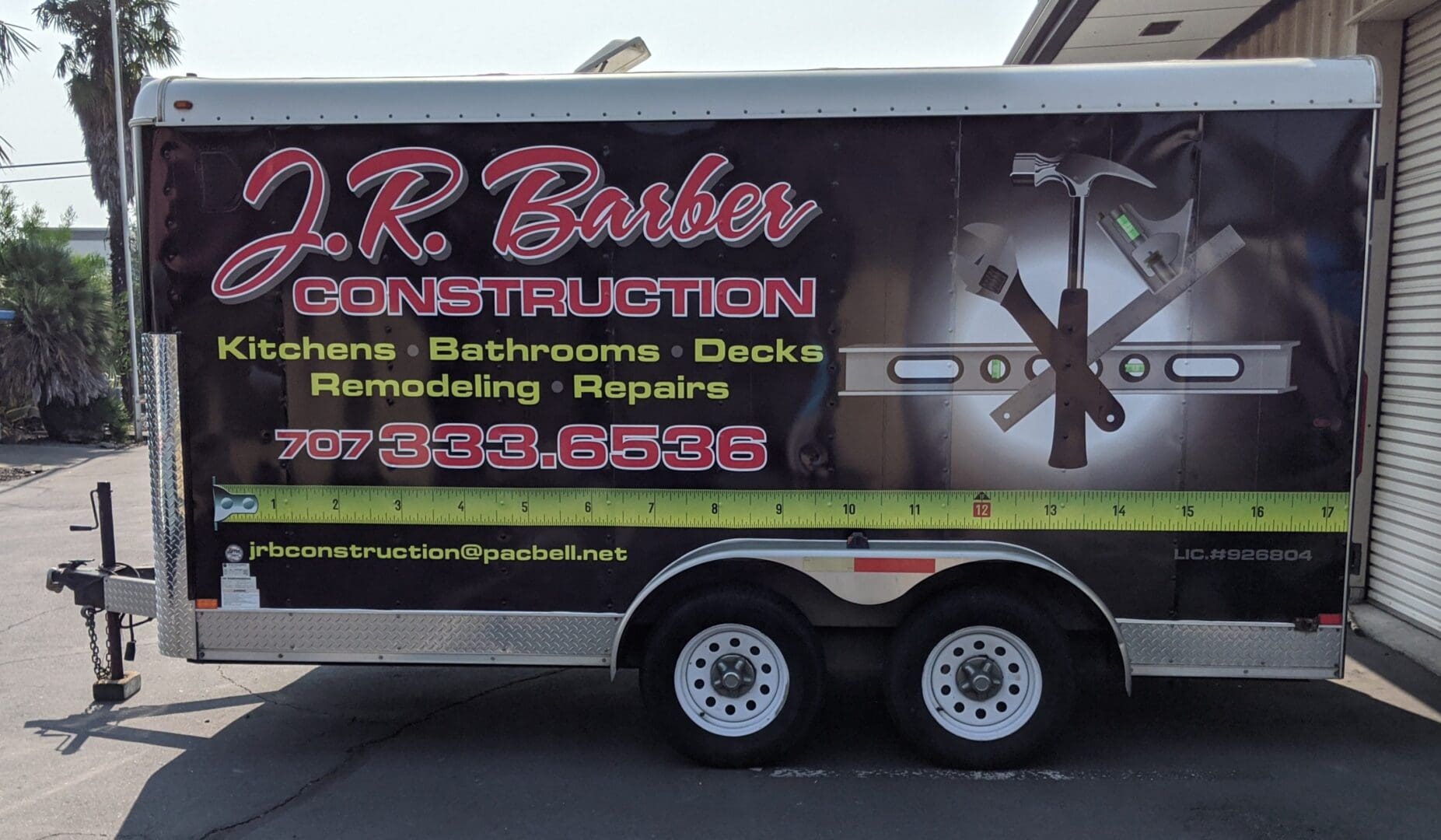 Construction company trailer with contact information.