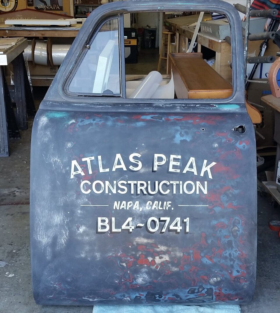 Old car door with construction company logo.